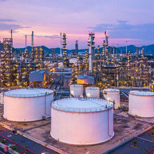 Aerial top view oil and gas chemical tank with oil refinery plant background at twilight.